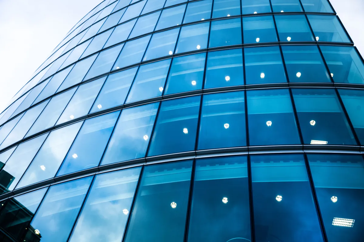 Façade vitrée bleutée sous ciel bleu – film solaire Silver Top Ext. Moyen